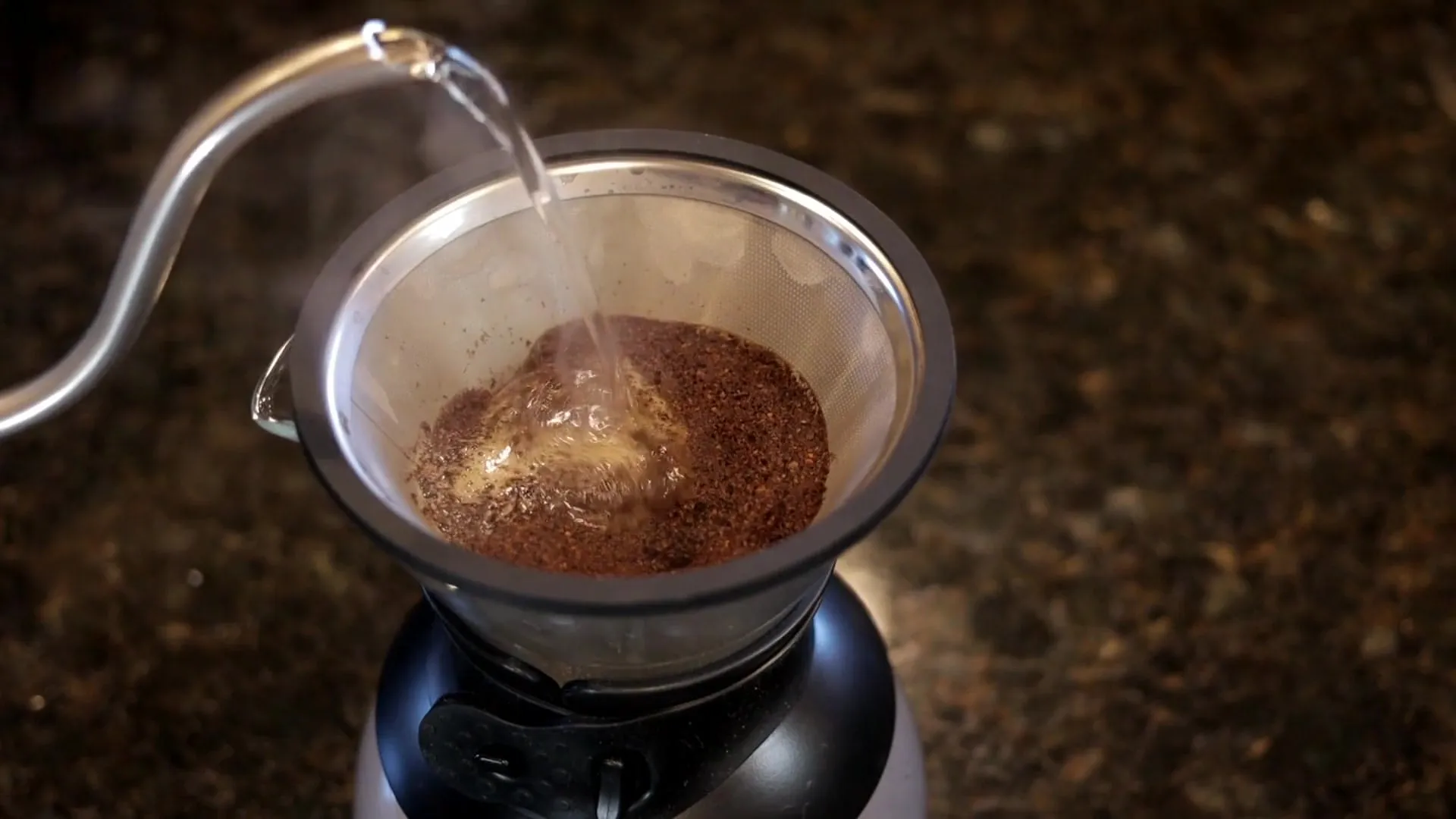 Apă fierbinte turnată în spirală peste cafeaua măcinată dintr-un filtru conic